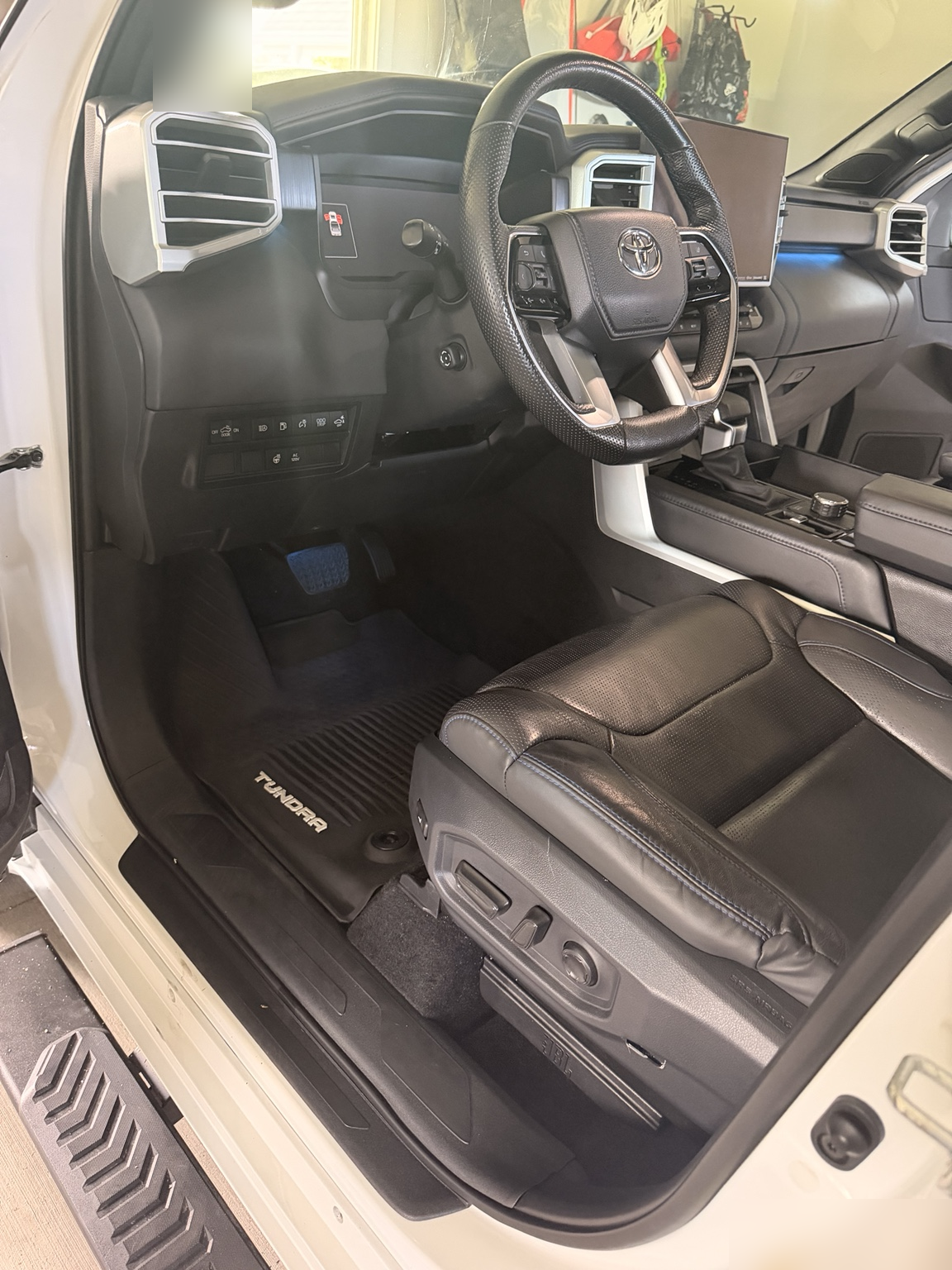 The same Toyota Tundra interior after detailing, with a clean floor mat, seat, and door sill.